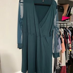 Green knee length dress with sheer sleeves.